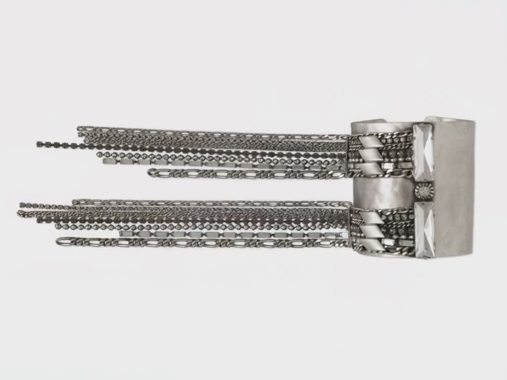 Carica il video: Bracciale a schiava in finitura argento, composto da molteplici fili di catena e strass pendenti. Lyrren è una cascata di luce e movimento, pensata per avvolgere il polso con eleganza e magnetismo. Ogni gesto diventa una coreografia scintillante.
